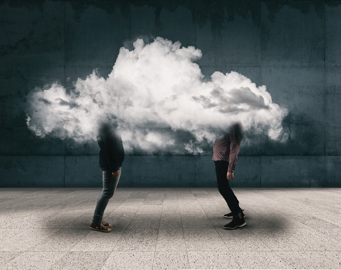 Image of a woman and man discussing with their head in a giant cloud