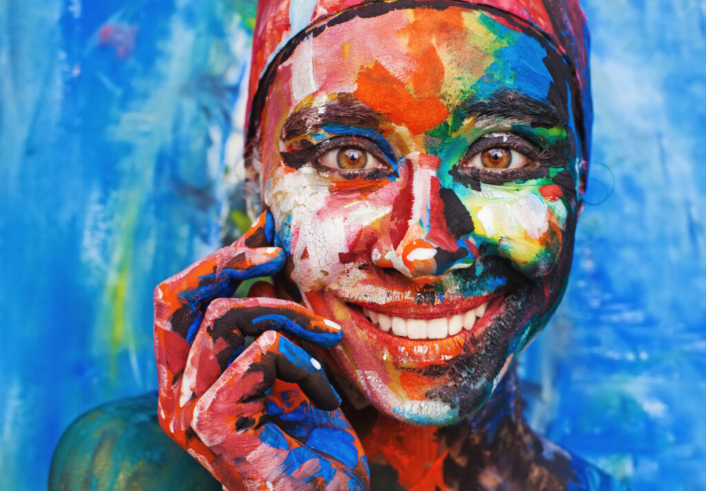 Woman covered in paint smiling at the camera