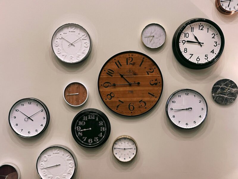 white and brown analog wall clock at 10 00 representing that time is precious and limited
