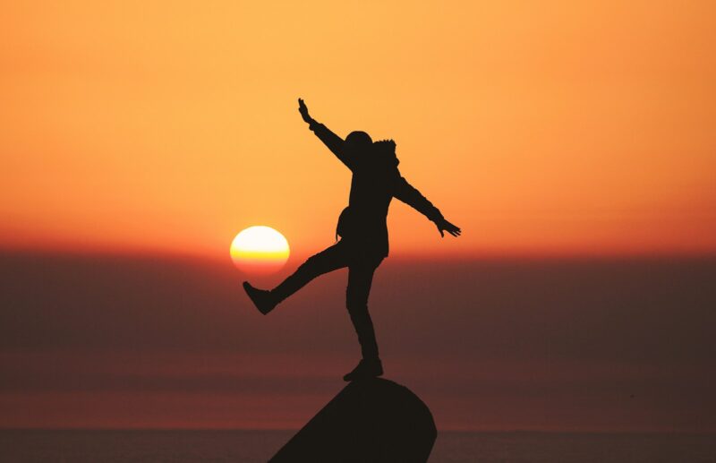 photo of silhouette photo of man standing on rock representing work-life balance and integration