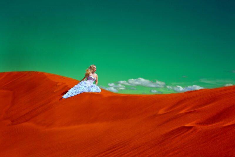 woman in white gown on desert representing supporting women struggling with PMDD