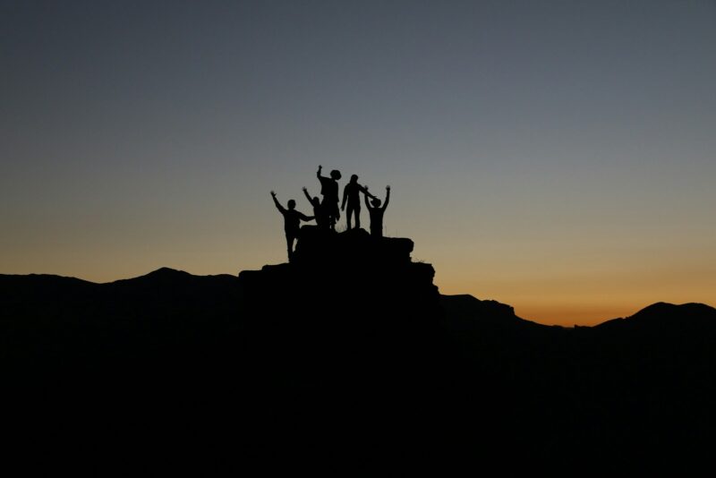 silhouette of people standing on highland during golden hours: leadership and being a supportive leader
