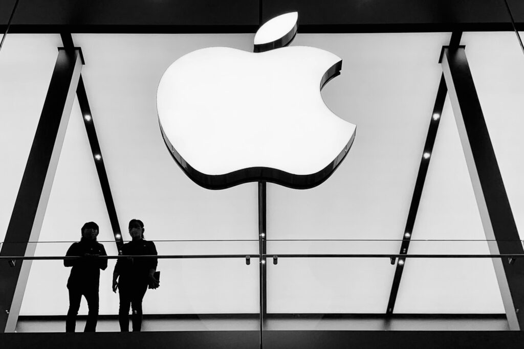 silhouette of people standing near wall: Apple