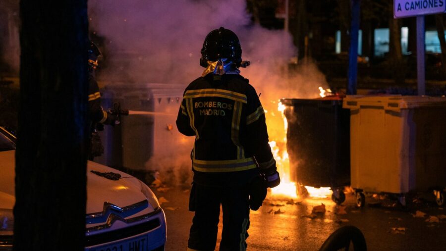 a firefighter standing in front of a fire, UK riots