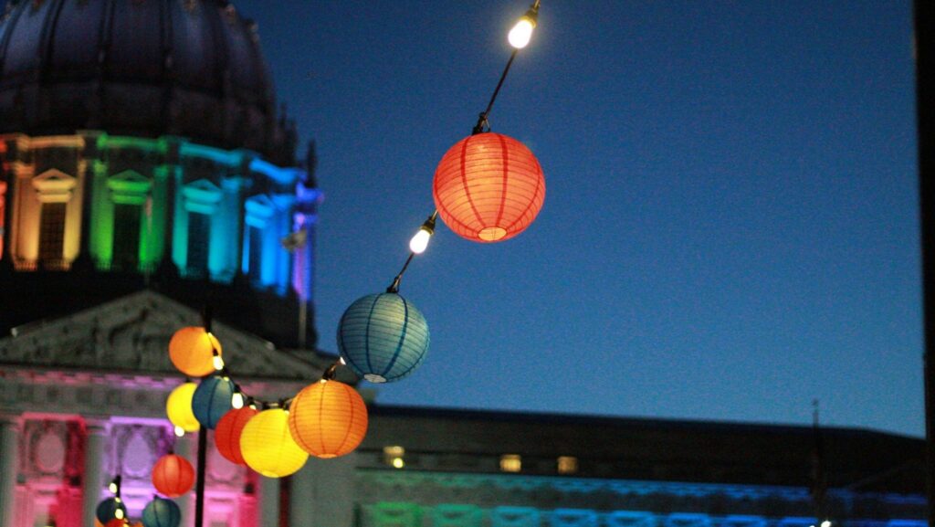 line of lighted lanterns in front of dome building during nighttime. Inclusion at work.