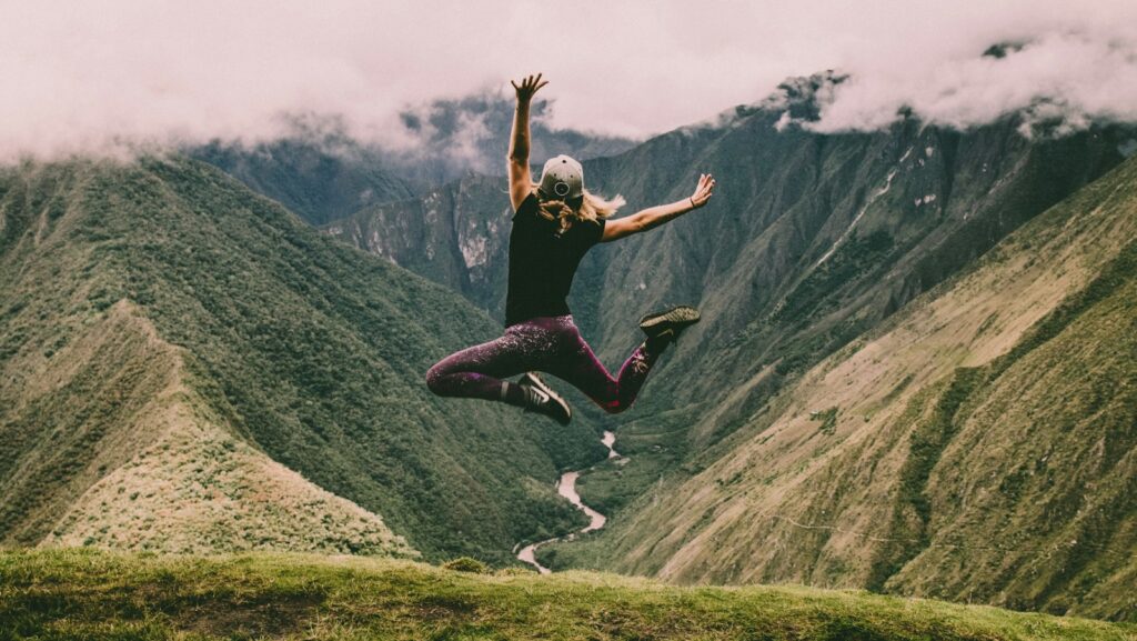 woman jumping on green mountains, menopause action plan