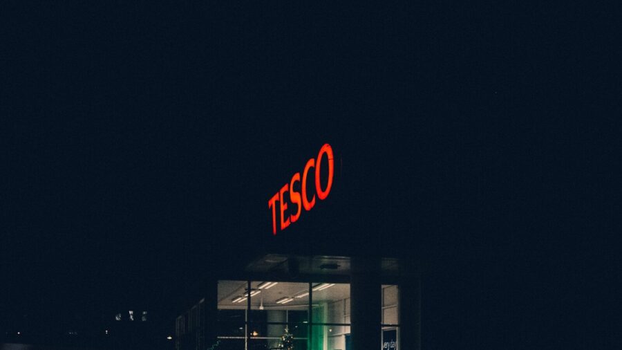 red and white open neon signage: Tesco fire and rehire employees/employers