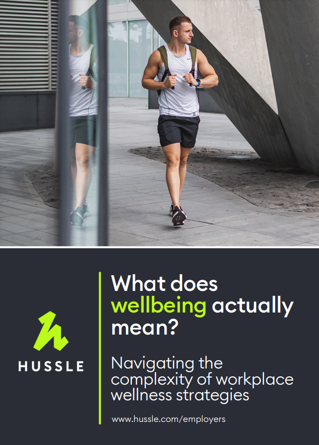 Man in athletic wear walking outside. Text reads: "What does wellbeing actually mean? Navigating the complexity of workplace wellness strategies." Hussle logo and website included.