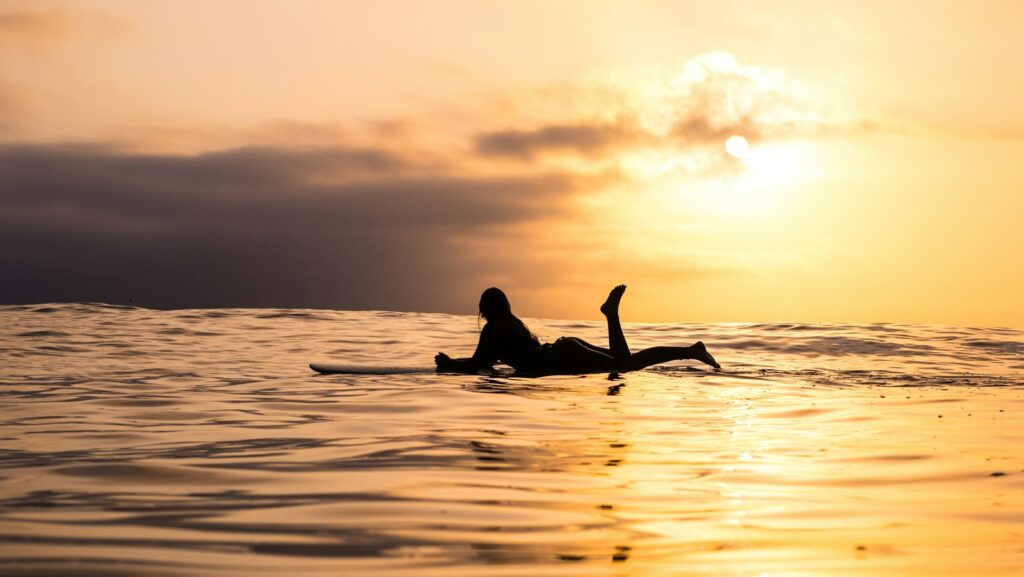 silhouette of woman lying on surfboard at the sea. Next-level relationships