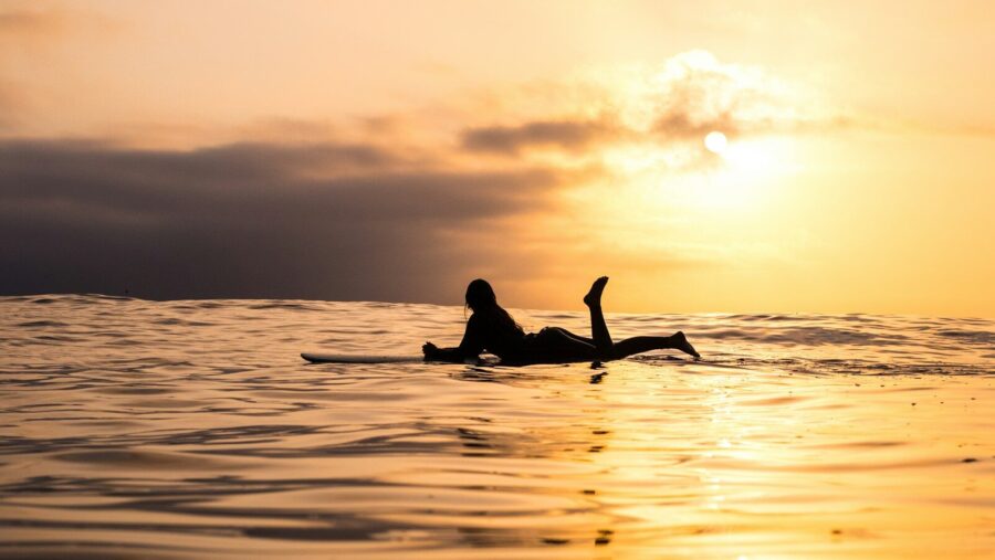 silhouette of woman lying on surfboard at the sea. Next-level relationships