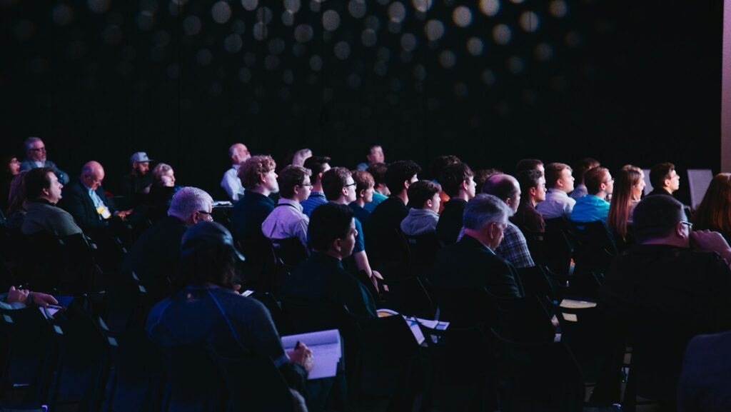 crowd of people sitting on chairs inside room