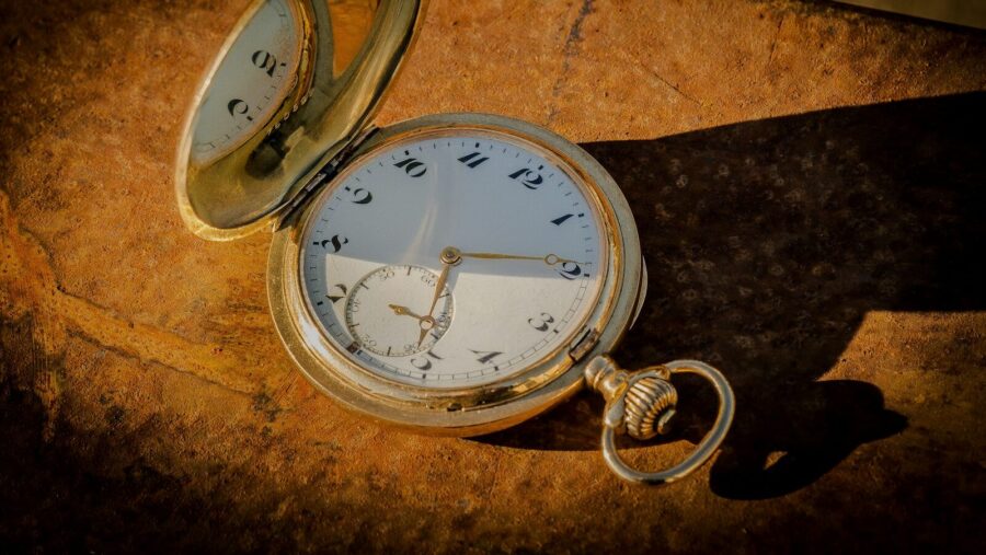 an old pocket watch laying on a rock