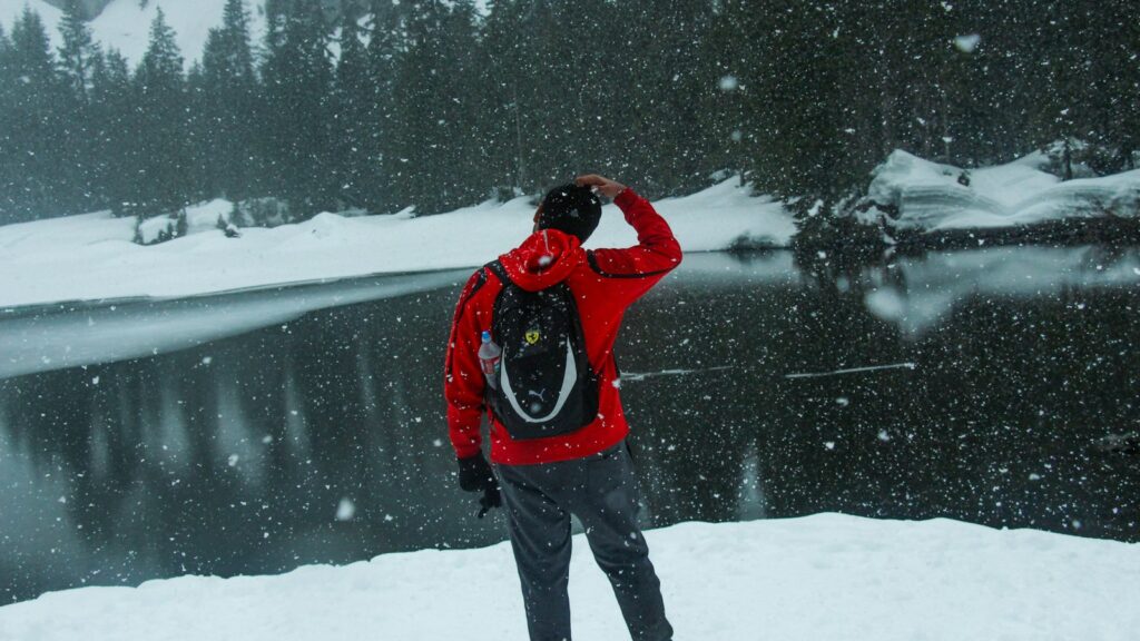 a man in a red jacket standing in the snow