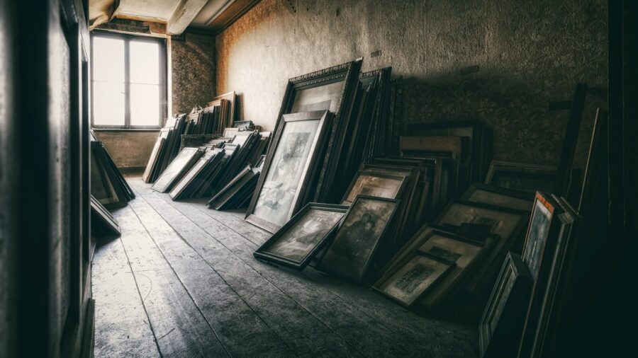 a room filled with lots of framed pictures next to a window, lost arti of team building