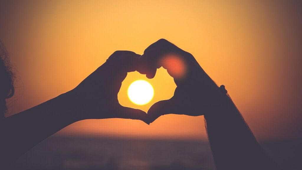 silhouette of person's hands forming heart, emotional recession