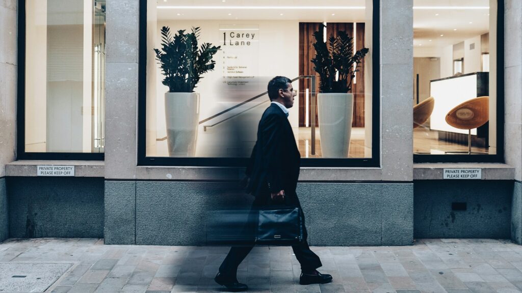 man in black suit jacket in walking gesture, WFH