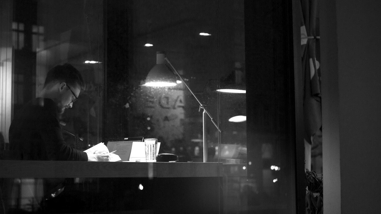 a man sitting at a desk in front of a window, right to work checks