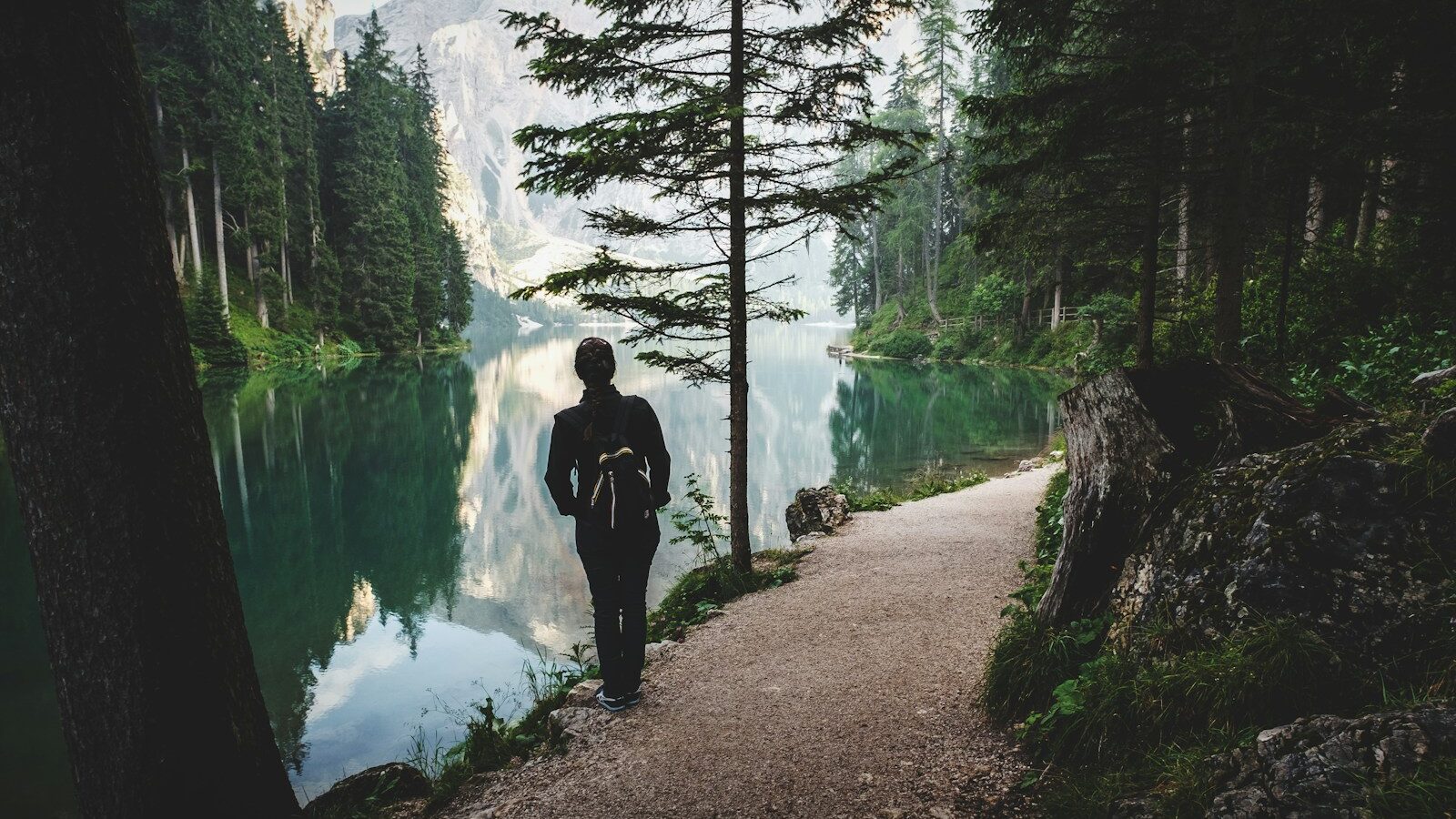 person stands near lake