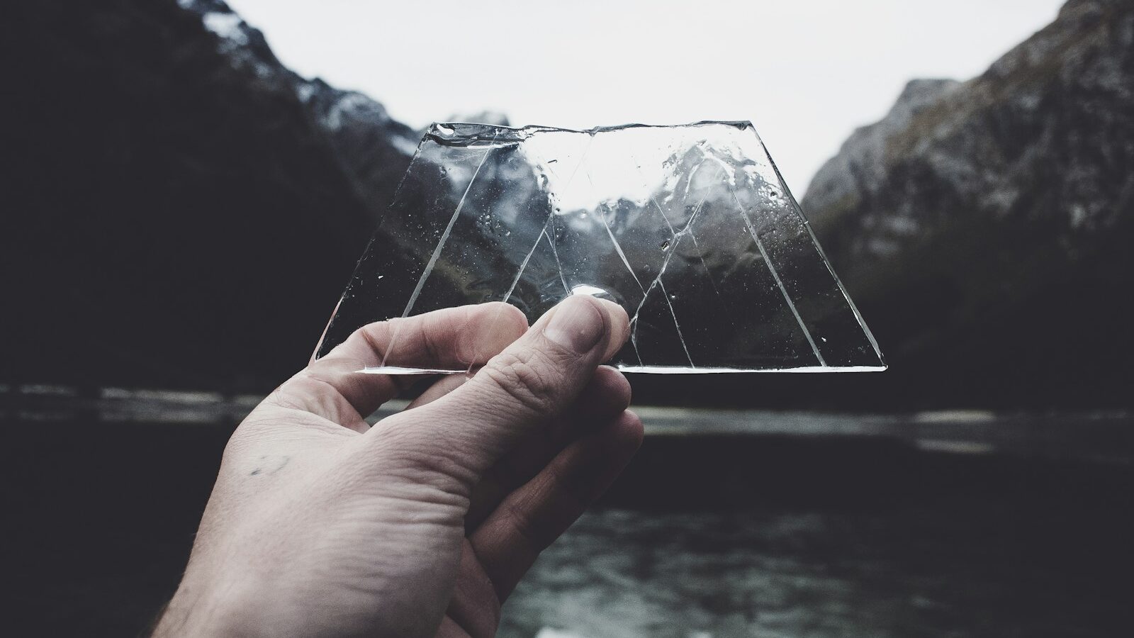 person holding clear glass panel