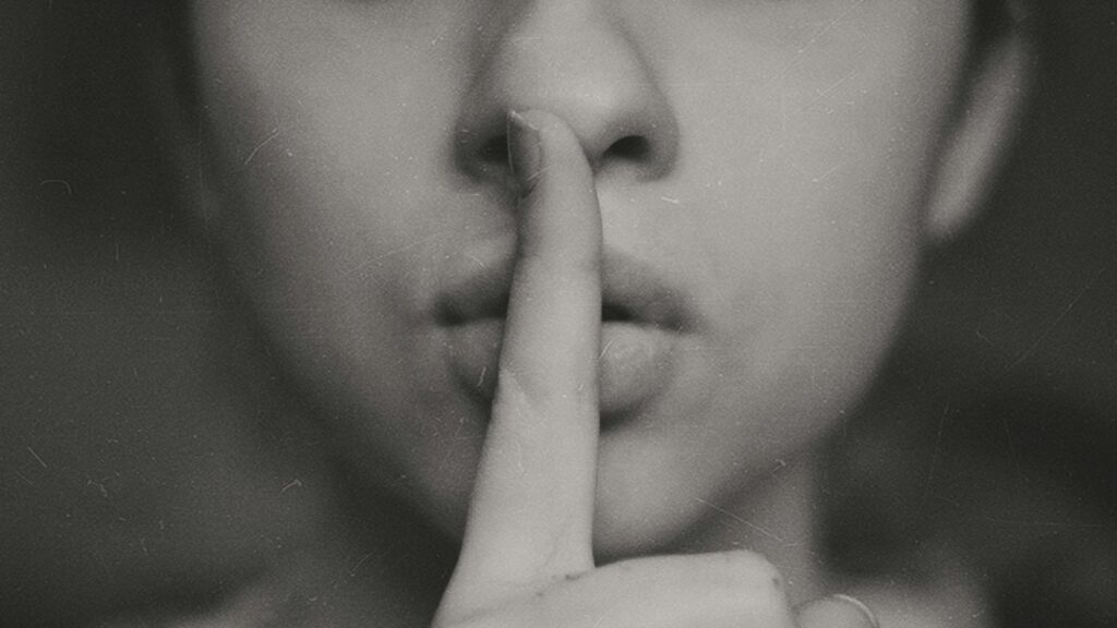 grayscale photo of woman doing silent hand sign