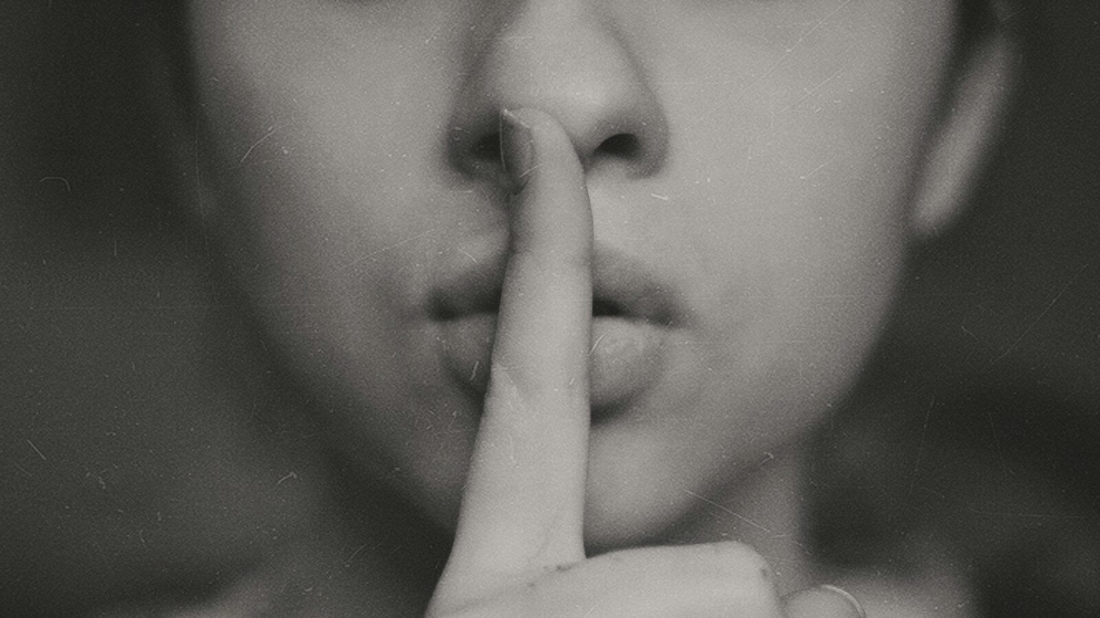 grayscale photo of woman doing silent hand sign