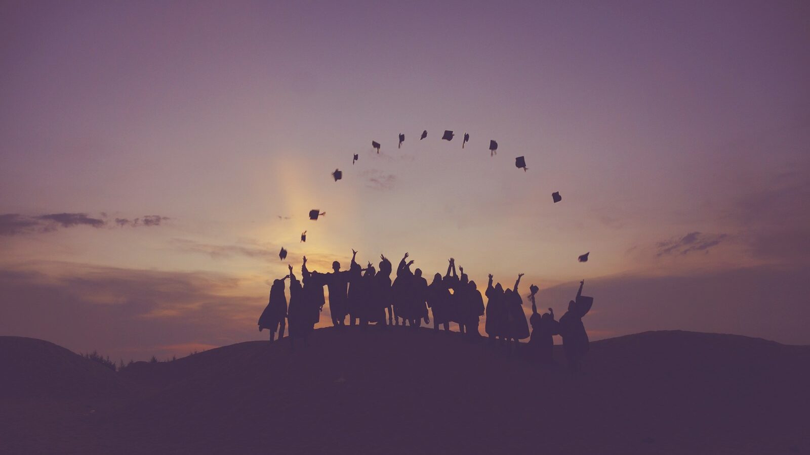 silhouette of people standing on hill - AI in graduate recruitment