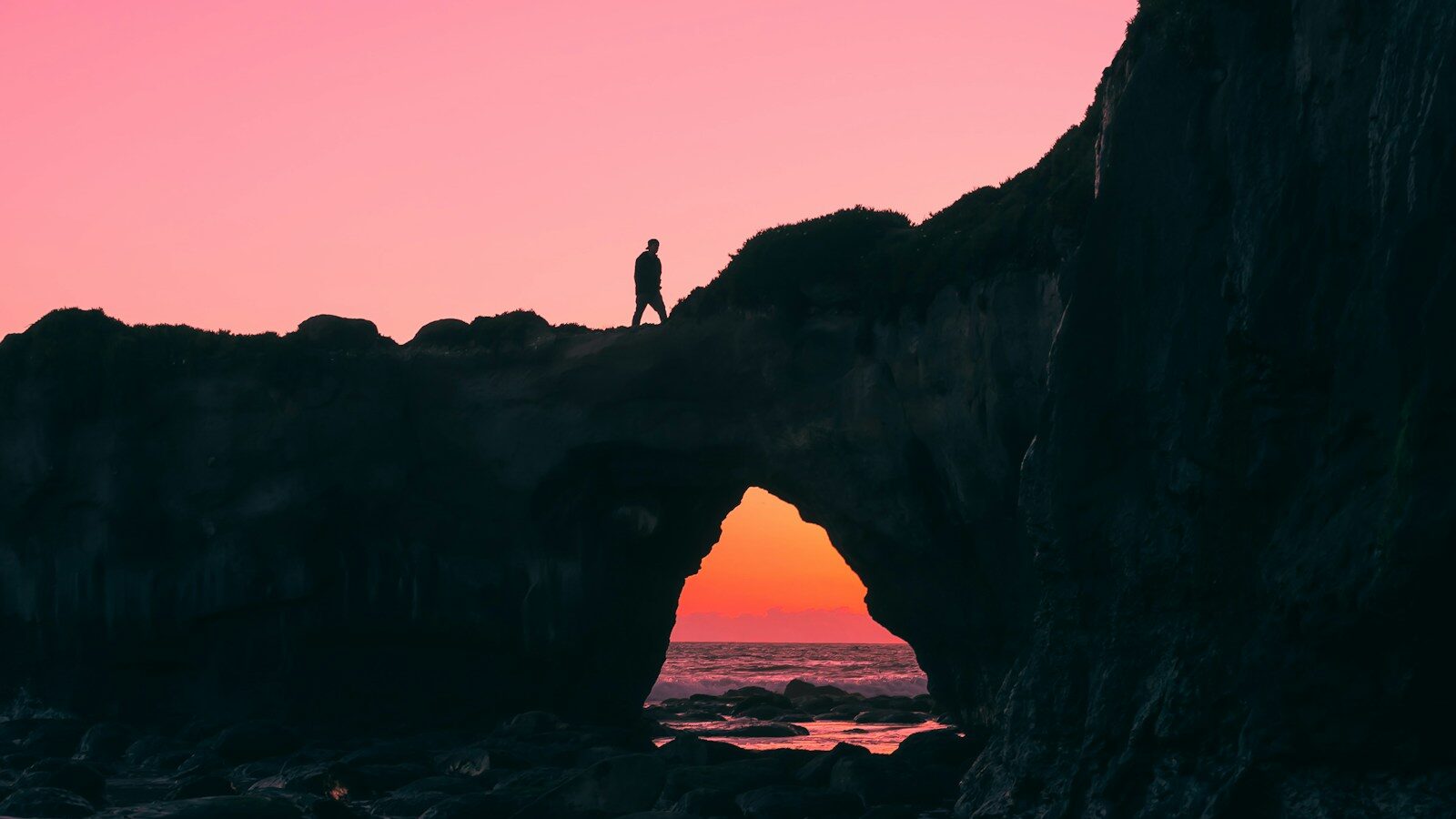 silhouette of man walking on top of large rock, depicting the CEO-employee wellbeing gap