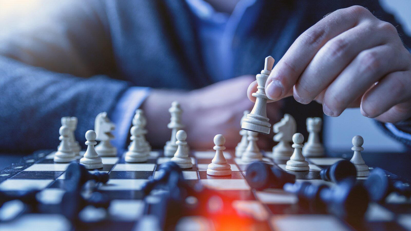 depth of field photography of man playing chess, representing the executive bonus debate