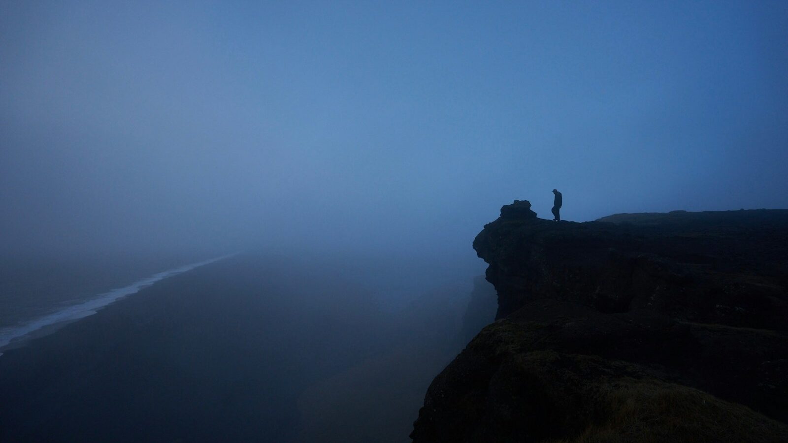 person standing rock cliff covered with fog, depicting Values Void