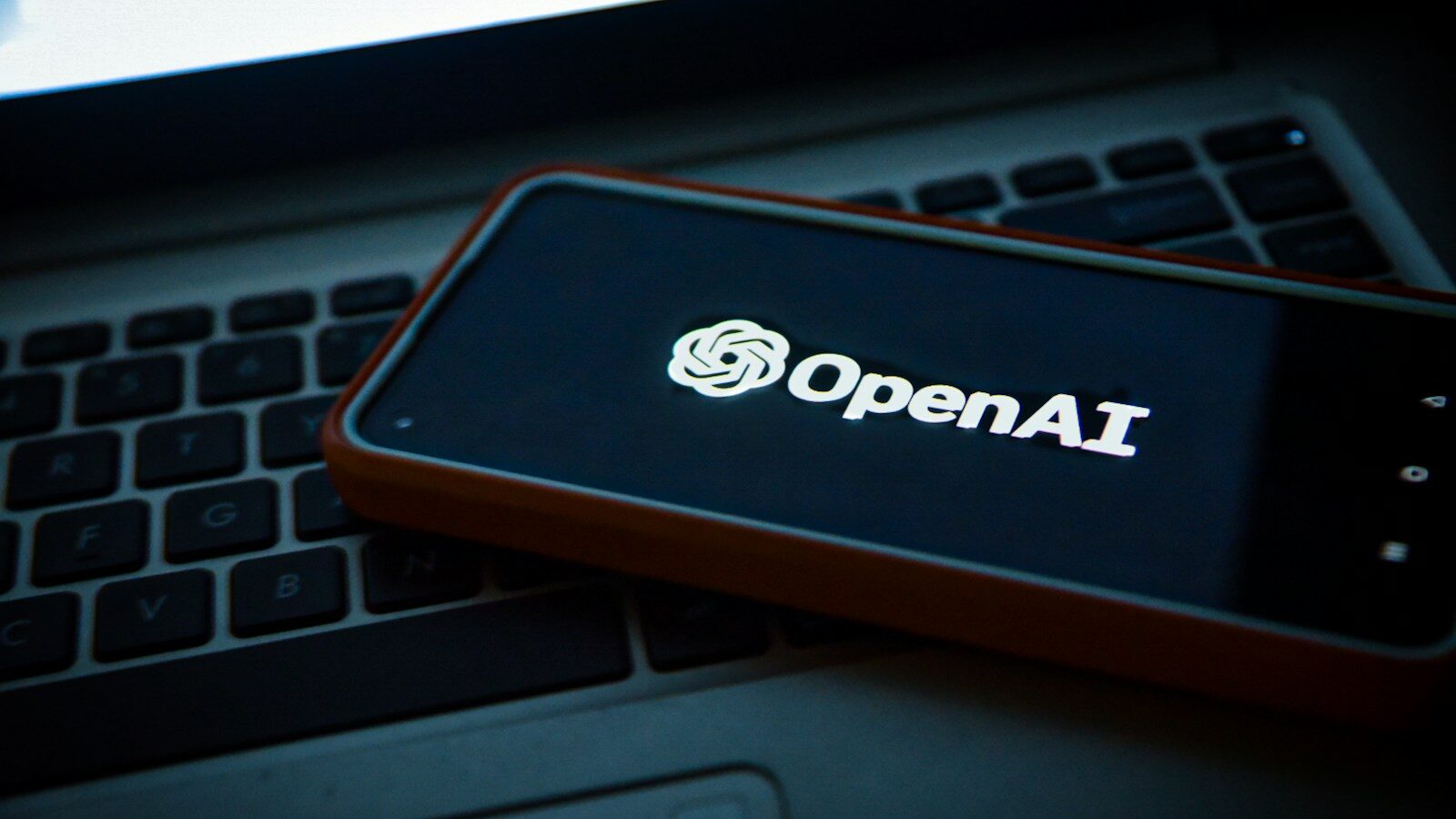 ChatGPT, a cell phone sitting on top of a laptop computer