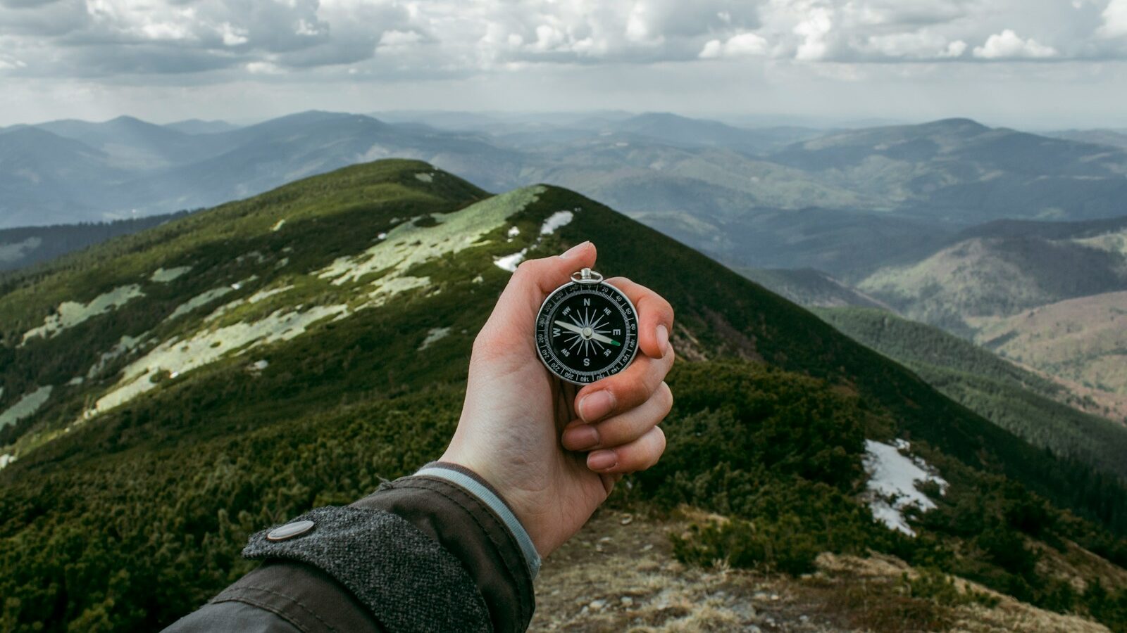 person holding silver compass